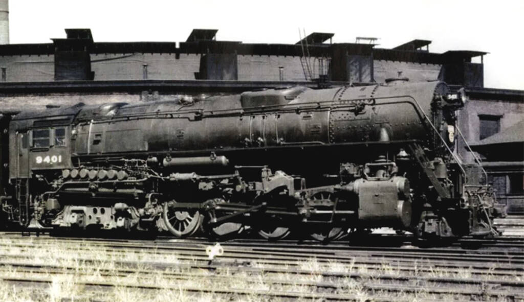 A black Berkshire steam locomotive and tender is shown stationary in a vintage color photo
