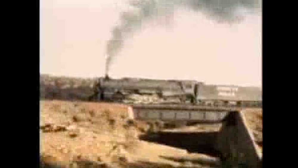 Steam locomotive on bridge with train