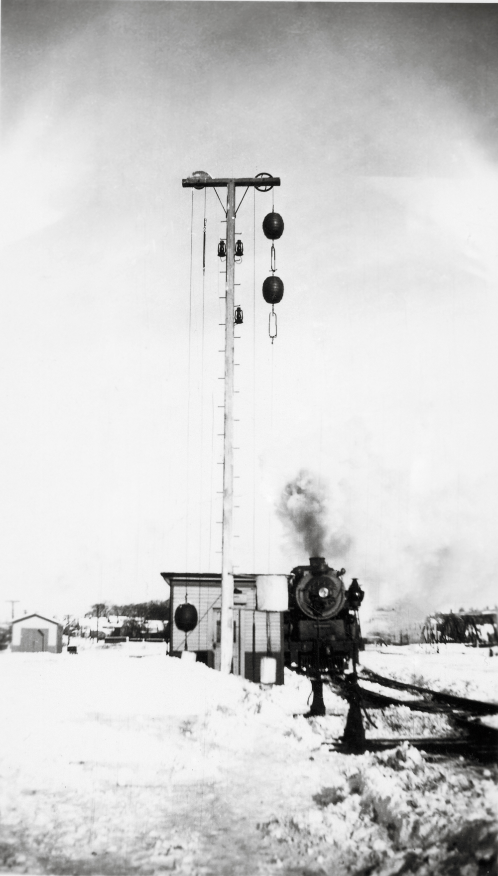 black and white photo of train by ball signal