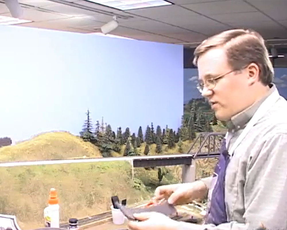 Cody Grivno next to layout with scenery