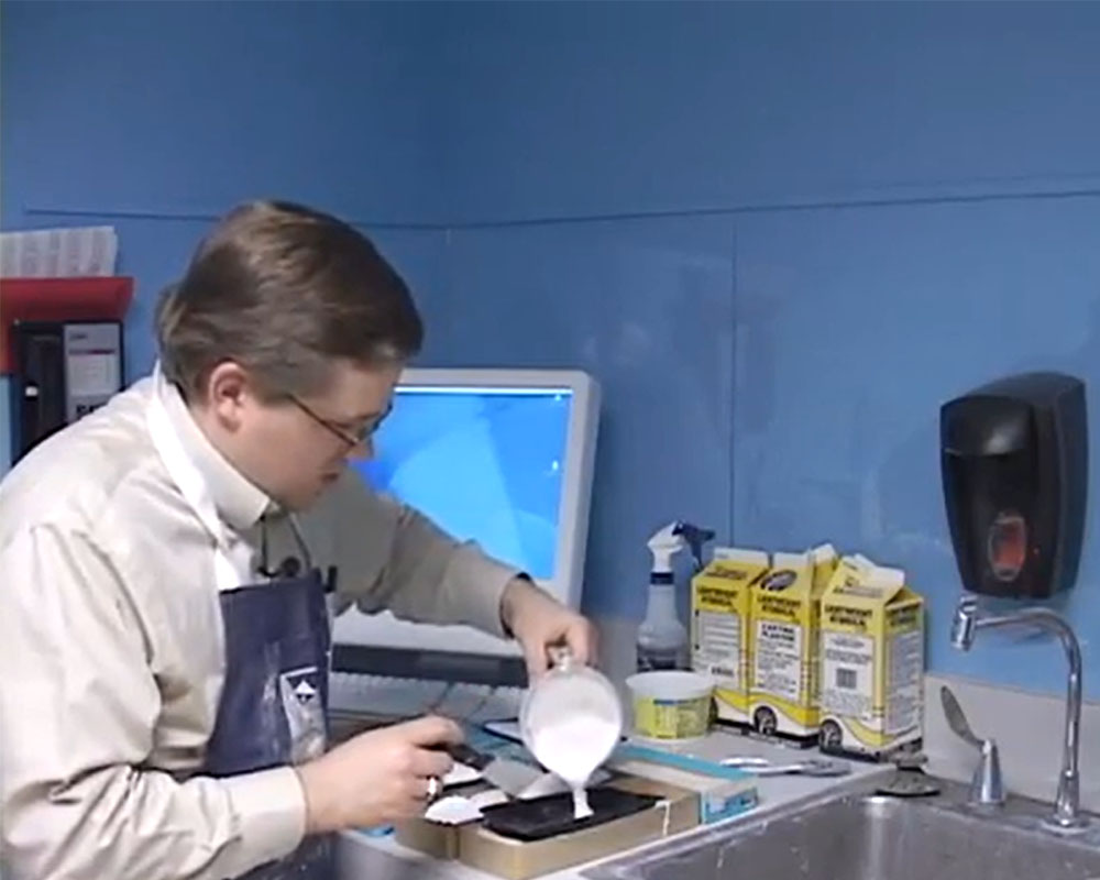 Cody Grivno pours plaster into a mold