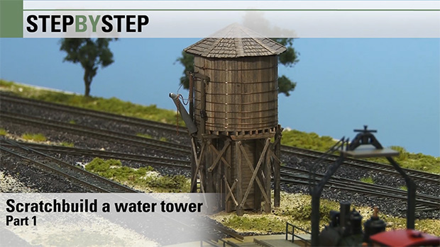 A water tank standing next to the tracks.