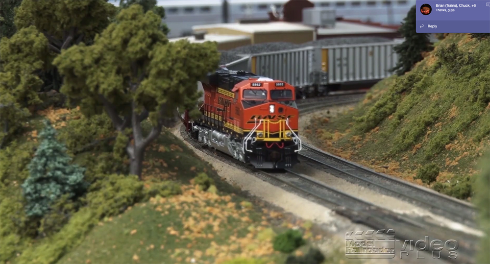 HO scale model train traveling down the tracks on a layout