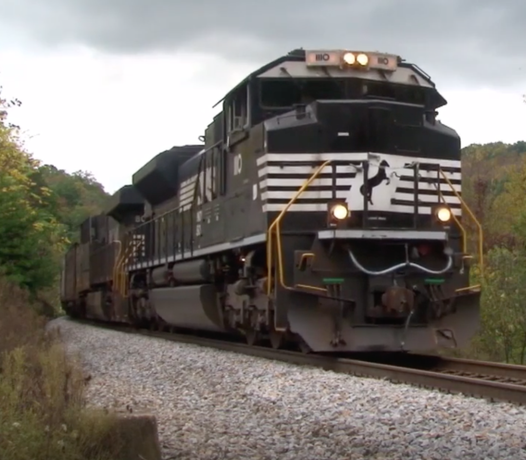 Black and white diesel locomotive hauling a freight train.