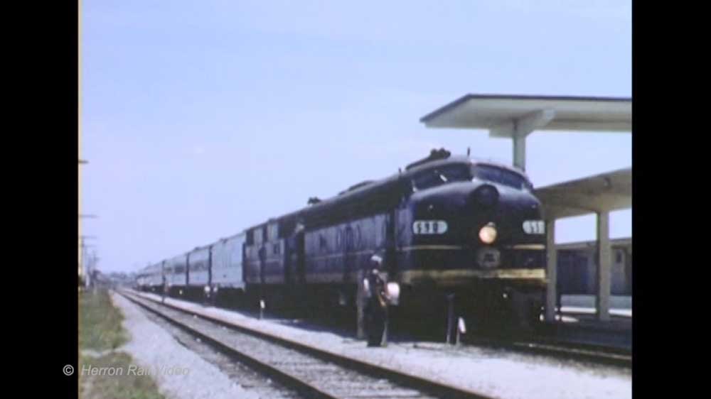 Black diesel locomotive with passenger train at station