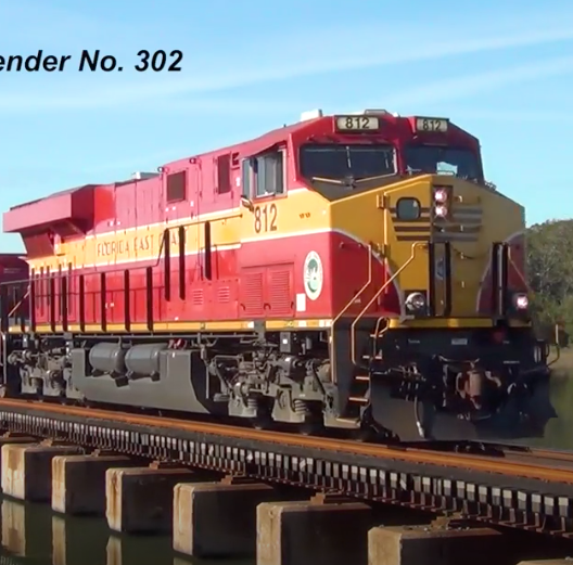Red-and-yellow locomotive moving over a bridge.