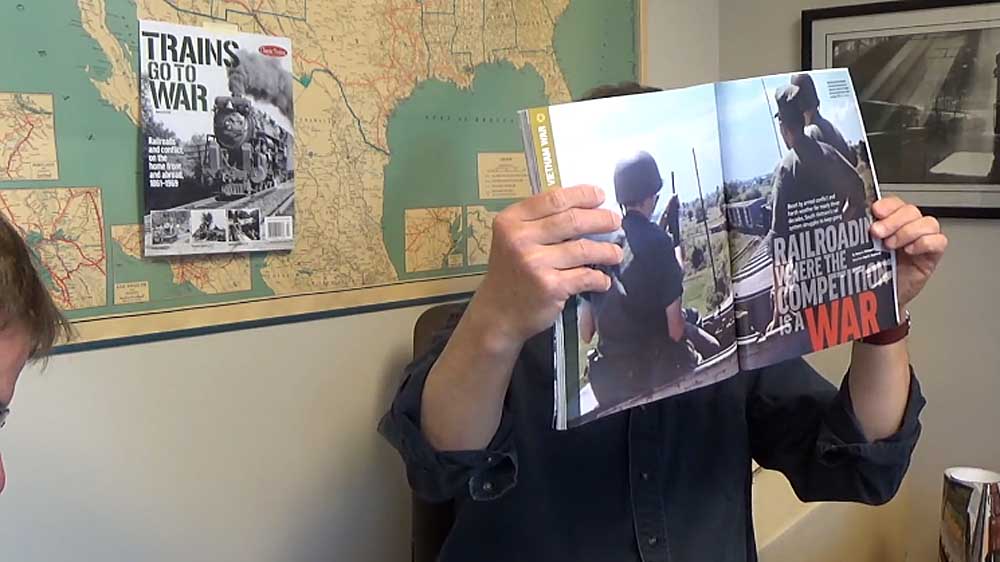 Person holding magazine in front of wall map