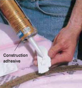 Hands applying adhesive to plaster scenery