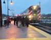 Passengers waiting in the rain to board the metra