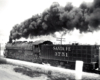 A train speeding by with black smoke coming out of its chimney