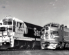 Two santa fe trains side by side on the tracks