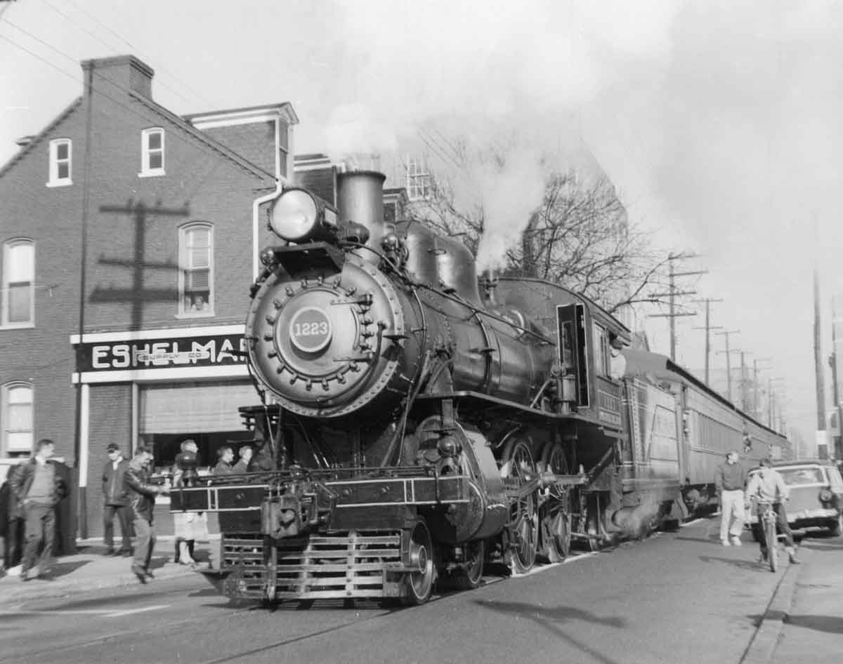 Steam locomotive with passenger train on street trackage