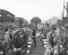 Men sit on railroad flatcars