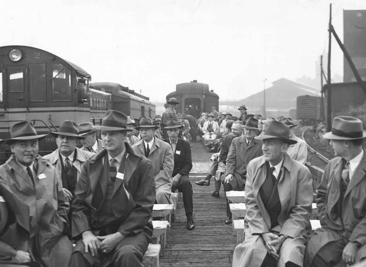 Men sit on railroad flatcars