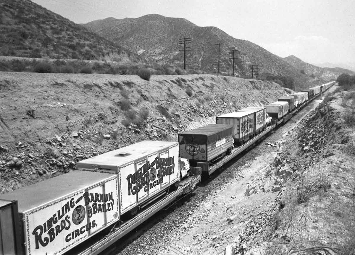 Circus wagons on flatcars in hills