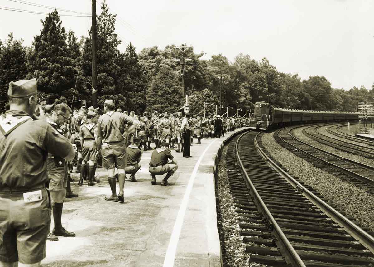 Boy scouts in uniform wait for arriving passenger train