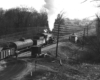 A black and white photo of the Chesapeake & Ohio No. 350 locomotive leaving the rail yard with white smoke coming out of its chimney