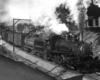 A black and white photo of ten-Wheeler 352 locomotive on the track with steam coming out of its chimney