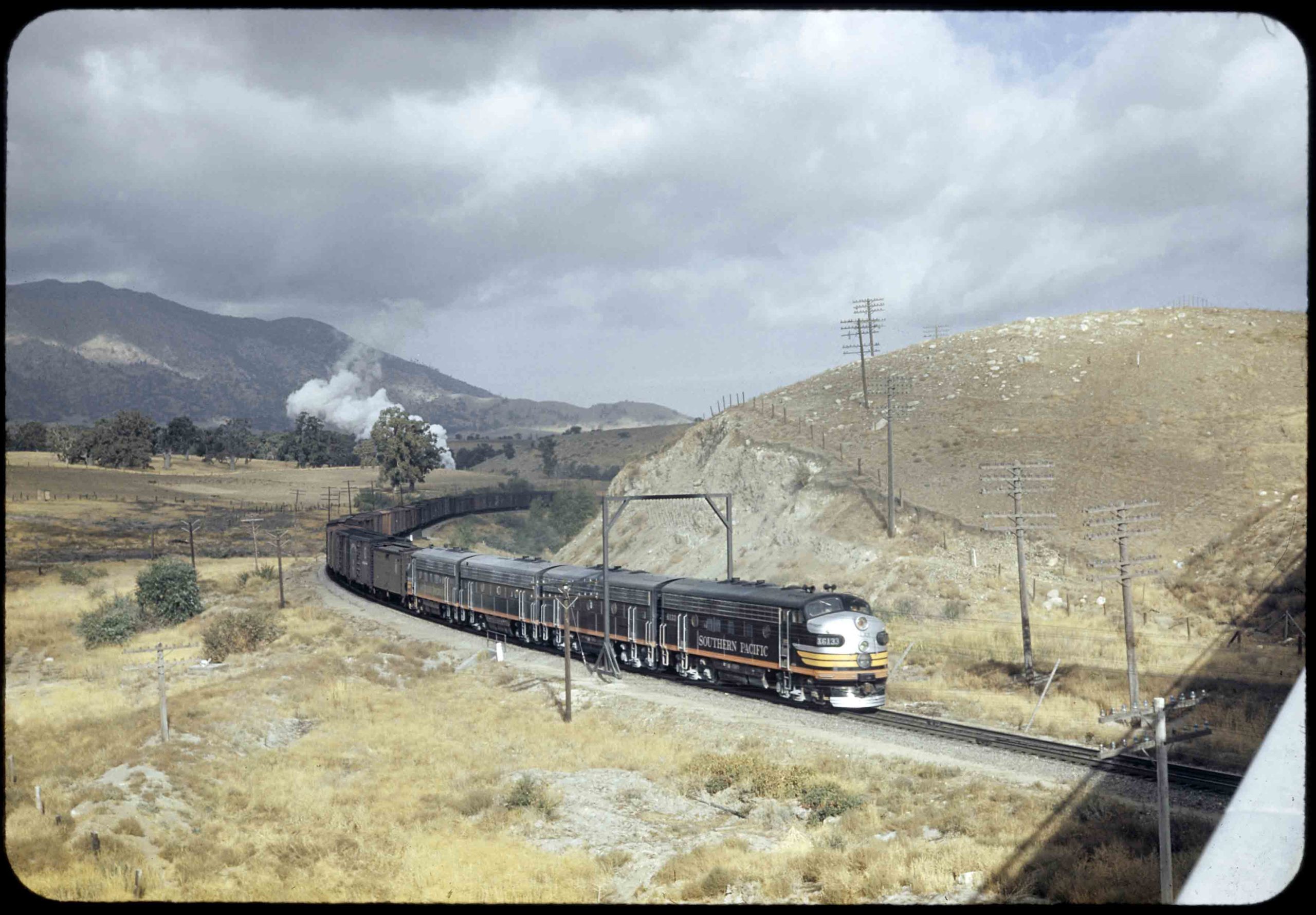 Freight train in an arid, mountainous landscape.