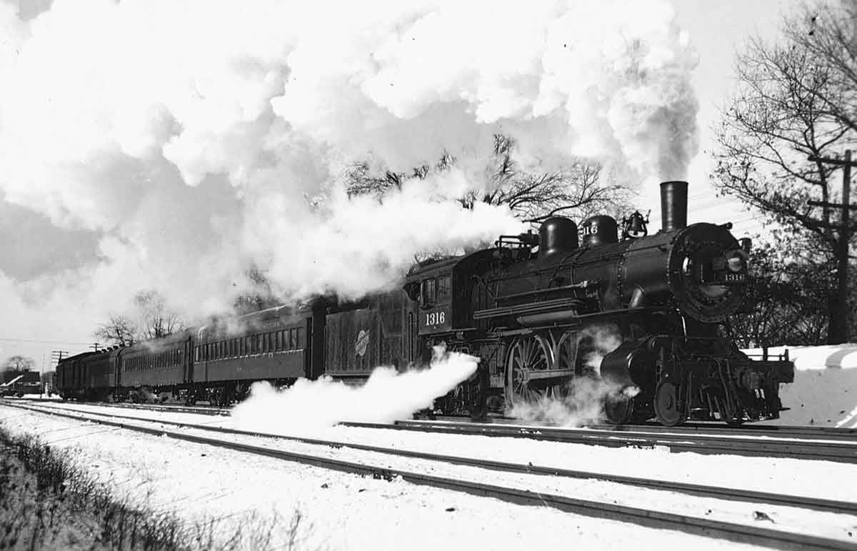 Steam Chicago & North Western locomotives with passenger train in snow