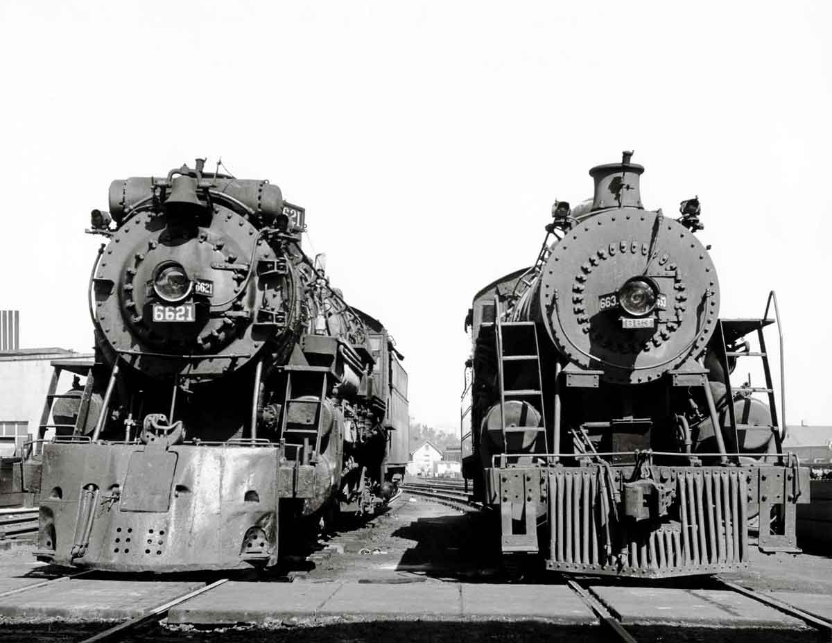 Smoking steam Frisco and Missouri Pacific locomotives at service tracks