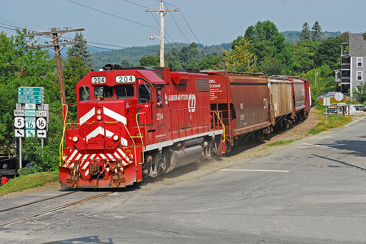 A red train passing through a town