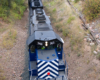 A train passing below another train traveling over a bridge