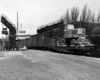 A black a white photo of the City of Saginaw 31 locomotive getting loaded with construction equipment at a rail yard