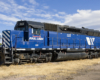 A blue train sitting on the tracks