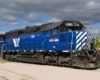 A blue train parked on a cloudy day