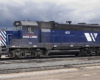 A blue train parked on a cloudy day