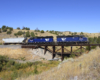 A blue train passing over a bridge