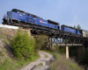 A blue train passing over a bridge