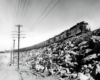 A black and white photo of a SD24 locomotive on a raised railroad