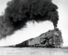 A black and white photo of a 2-10-4 locomotive with big black smoke coming out of its chimney