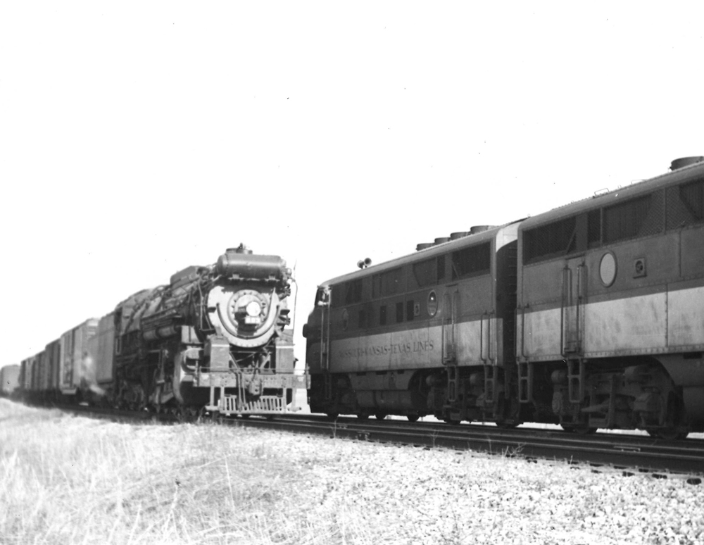 A black and white picture of the locomotive Katy F3s waiting behind another locomotive on the tracks
