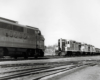 a freight train in the background approaching a diesel in the foreground