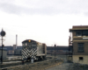 A Santa Fe H10-44 switcher locomotive passes by a guys standing outside a terminal tower