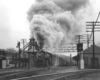 a steam engine pulling freight with a huge plume of smoke