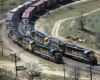 Two navy blue and yellow Santa Fe locomotives turning the bend at the same time