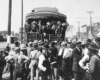 People crowd around rear of passenger train