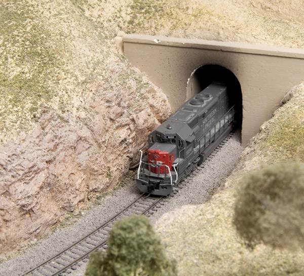 Adventures in code 55 track: An image of a model locomotive emerging from a tunnel