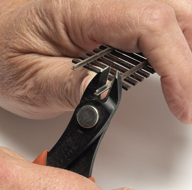 A rail nipper is used on an uneven stretch of model railroad track. 