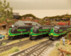 Three black and green cab-unit style diesel-electric locomotives side by side.