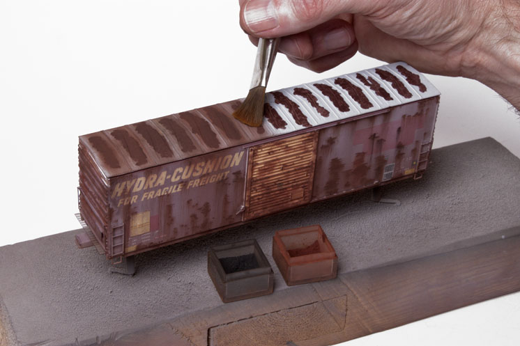 Pelle Soeborg using a paint wash to weather model train boxcars
