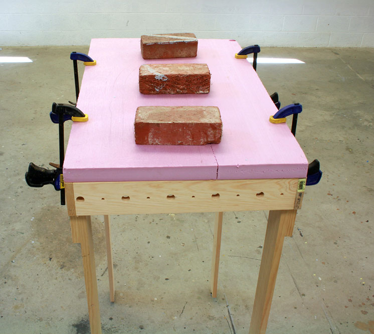 An image of foam board being adhered to bench work.