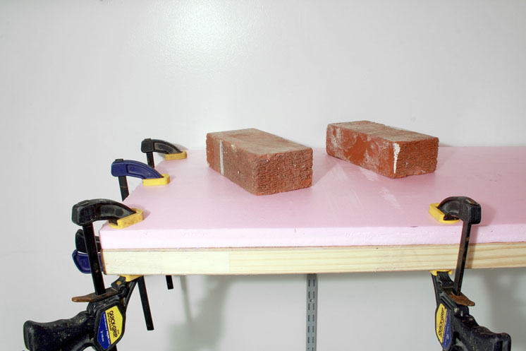 An image of foam board being adhered to shelf benchwork.