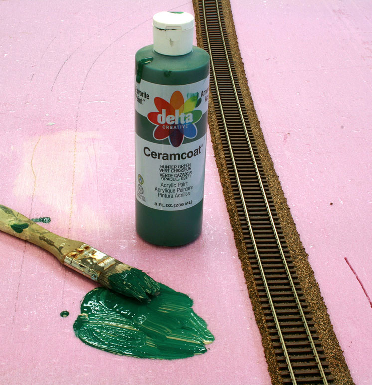 An image of green paint being applied onto foamboard.