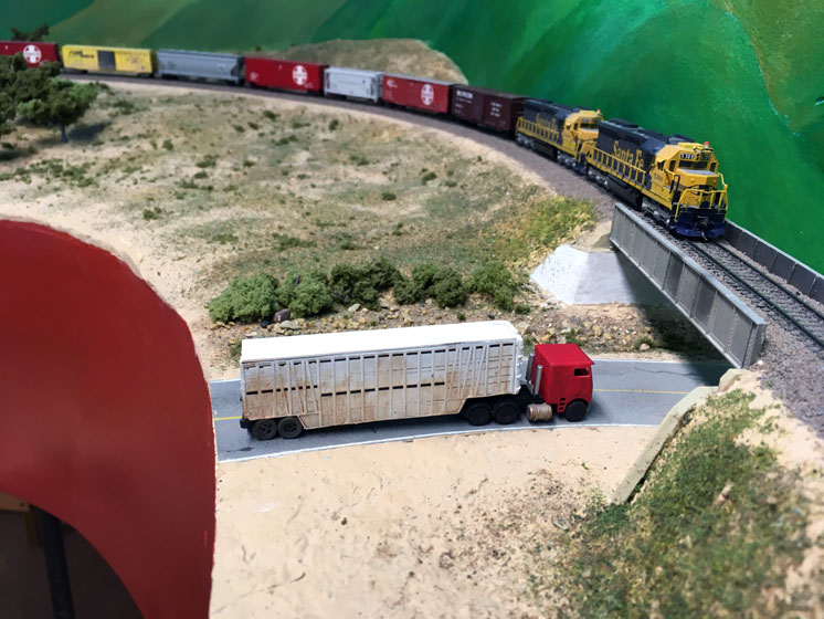 A signature N scale truck for Tehachapi: An image of a model truck driving beneath a railroad