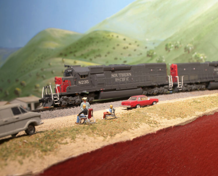 Tips for N scale figures: An image of a model locomotive on a model railroad layout with onlooking figures